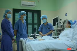 Bác sĩ giúp chị H. tập phục hồi chức năng tại giường (Ảnh: Quang Hùng)