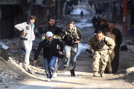 Các nhà báo mạo hiểm băng qua một con đường trong thành phố đang có chiến sự Aleppo ở Syria năm 2012 - Ảnh: Reuters