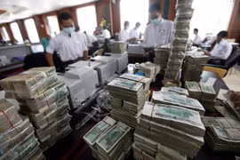 Thủ quỹ đang kiểm tiền tại một ngân hàng tư nhân ở TP Yangon, Myanmar. Ảnh: Reuters
