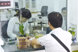 Giao dịch tại Vietcombank. Đây là một trong số ít ngân hàng có mức trả cổ tức bằng tiền ở mức 10-12%/năm. Ảnh: UYÊN VIỄN