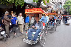 Du khách nước ngoài thăm phố cổ Hà Nội bằng xe xích lô. (Ảnh: Thanh Hà/TTXVN)