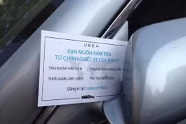 Một mẩu quảng cáo của Uber gắn trên kiếng xe chiếu hậu của chủ một xe hơi ở TPHCM