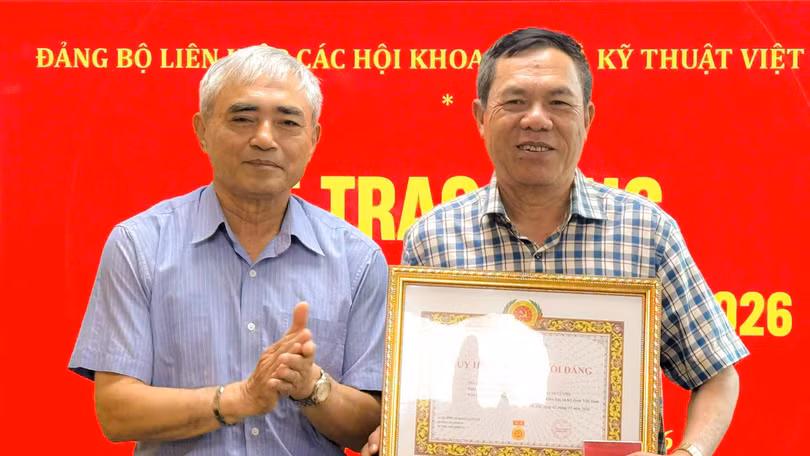 Ông Nguyễn Minh Hồng trao Huy hiệu 40 năm tuổi Đảng cho nhà báo Lê Đức Sảo tại buổi lễ.