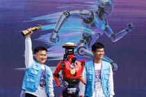 Các thành viên nhóm ăn mừng bên cạnh robot hình người Lightning của Honor. Ảnh: Reuters.