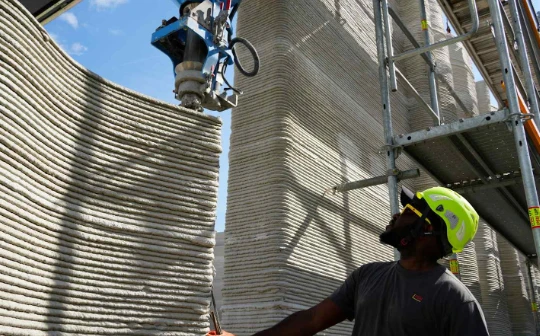 Một cánh tay robot thuộc hệ thống sản xuất bồi đắp đang xếp chồng các lớp bê tông để xây dựng tòa nhà in 3D lớn nhất châu Âu tại Heidelberg, Đức. Ảnh: Nikkei Asia.