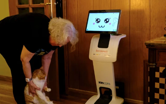 Irene Veglison, 67 tuổi, ôm con mèo tên Sweet của mình bên cạnh con robot có biệt danh "Sandi". Ảnh: 