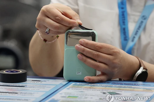 Nếu mang pin sạc lên máy bay phải dùng băng keo cách điện dán kín cổng ra. Ảnh: Yonhapnews.