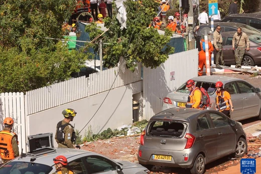 Các nhân viên cứu hỏa và y tế cứu hộ một địa điểm bị trúng tên lửa ở thành phố Rehovot, miền Trung Israel. Ảnh: Xinhua.