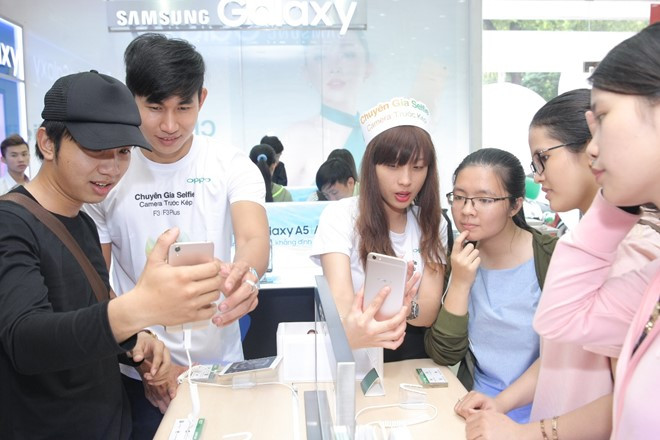 Khách hàng chăm chú khi được nhân viên hướng dẫn trải nghiệm sản phẩm mới.