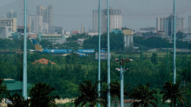 Một máy bay cỡ lớn vừa đáp hết đường băng khuất sau hàng rào lưới chắn bóng của khu tập golf.