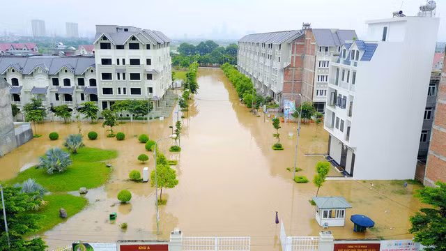 Lối dẫn vào các khu đô thị mênh mông nước. Nhiều người phải bắc ghế để di chuyển qua các đoạn ngập nặng.