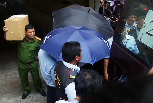 Cảnh sát đưa hai nghi can và tài liệu chứng từ đi. Ảnh: Quốc Thắng.