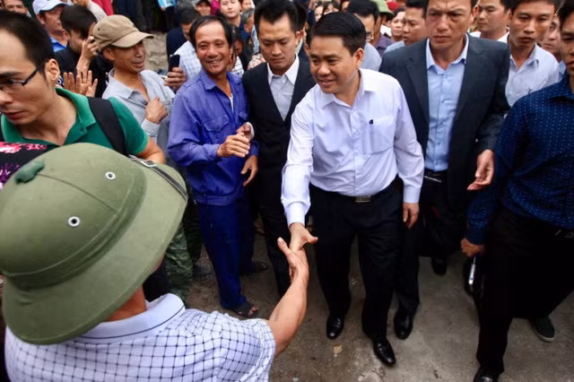 Ông Nguyễn Đức Chung, chủ tịch UBND TP Hà Nội, bắt tay người dân sau khi kết thúc buổi đối thoại với người dân tại thôn Hoành - Ảnh: NGUYỄN KHÁNH