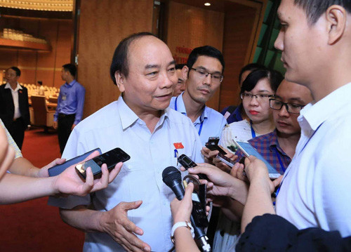 Thủ tướng Nguyễn Xuân Phúc trao đổi với báo chí bên hành lang QH - Ảnh: VGP