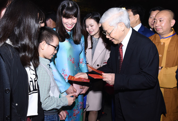 Tổng bí thư thăm hỏi, chúc Tết, mừng tuổi các cháu bé đang cùng gia đình tề tựu quanh Hồ Gươm chờ đón giao thừa.