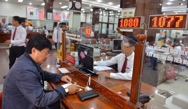 Khách hàng giao dịch tại một ngân hàng ở Q.1, TP.HCM - Ảnh: D.Ph. 