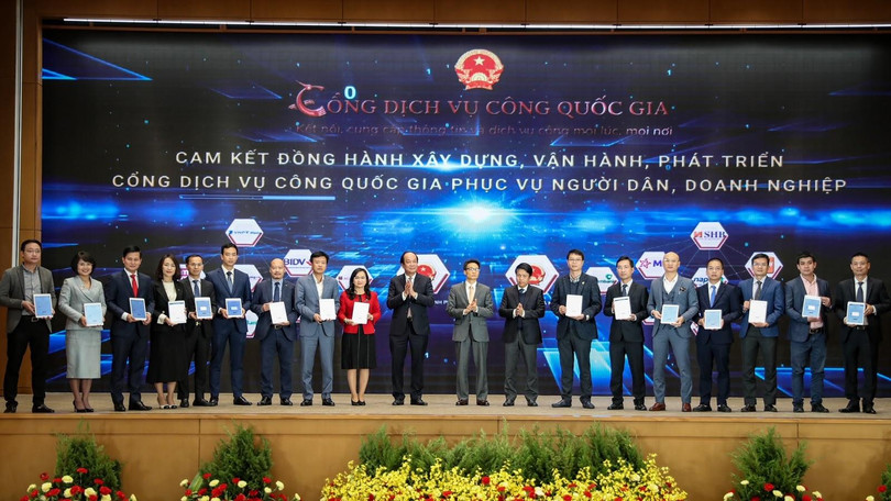 Phó Tổng giám đốc VPBank Đinh Văn Nho (thứ 5 từ trái sang) và các doanh nghiệp ký cam kết đồng hành xây dựng, phát triển Cổng Dịch vụ công quốc gia. (Ảnh: Minh Sơn/Vietnam+)