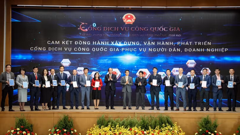 Phó Tổng giám đốc VPBank Đinh Văn Nho (thứ 5 từ trái sang) và các doanh nghiệp ký cam kết đồng hành xây dựng, phát triển Cổng Dịch vụ công quốc gia. (Ảnh: Minh Sơn/Vietnam+)