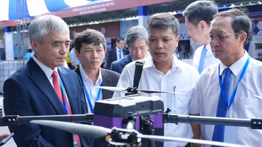 Ông Nguyễn Minh Hồng, Chủ tịch Hội Truyền thông số Việt Nam (bên trái), cùng các đại biểu tham quan khu trưng bày công nghệ bên lề hội nghị. Ảnh: Tùng Lâm.