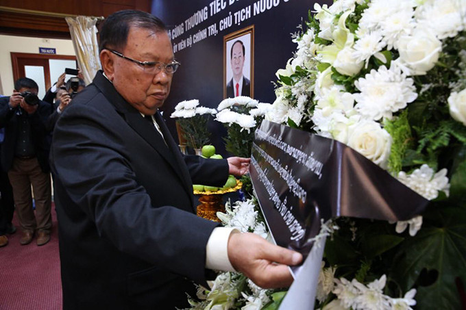 Sáng 26/9, Đại sứ quán Việt Nam tại Lào tổ chức Lễ viếng Chủ tịch nước Trần Đại Quang, đồng thời mở sổ tang để lãnh đạo, các cơ quan, đoàn thể, các đoàn ngoại giao, tổ chức quốc tế tại Lào đến viếng và ghi sổ tang. Sau nghi lễ treo cờ rủ trước trụ sở Đại sứ quán là lễ dâng hương tưởng niệm. Tổng Bí thư - Chủ tịch nước Lào Bounnhang Vorachith đã đến đặt vòng hoa, thắp hương viếng Chủ tịch nước Trần Đại Quang. Ảnh: Hà Trung Sáng 26/9, Đại sứ quán Việt Nam tại Lào tổ chức Lễ viếng Chủ tịch nước Trần Đại Quang, đồng thời mở sổ tang để lãnh đạo, các cơ quan, đoàn thể, các đoàn ngoại giao, tổ chức quốc tế tại Lào đến viếng và ghi sổ tang. Sau nghi lễ treo cờ rủ trước trụ sở Đại sứ quán là lễ dâng hương tưởng niệm. Tổng Bí thư - Chủ tịch nước Lào Bounnhang Vorachith đã đến đặt vòng hoa, thắp hương viếng Chủ tịch nước Trần Đại Quang. Ảnh: Hà Trung