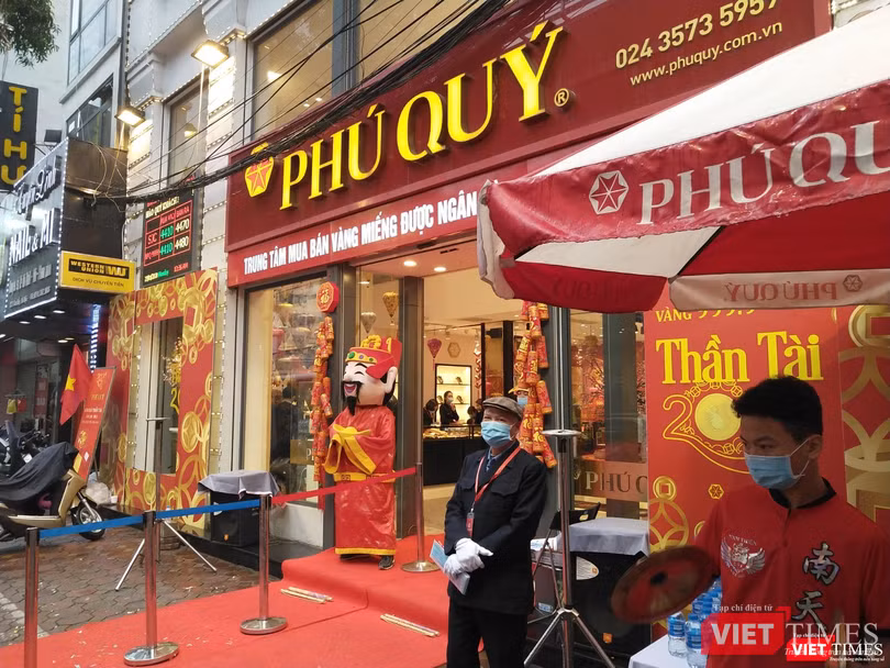 Nhân viên tại một tiệm vàng phát khẩu trang và nước miễn phí cho khách hàng Nhân viên tại một tiệm vàng phát khẩu trang và nước miễn phí cho khách hàng