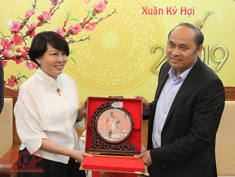 Đại diện Tập đoàn máy tính Lenovo (bên trái) tặng quà lưu niệm cho Chủ tịch UBND tỉnh Nguyễn Văn Linh (Ảnh: BGP/Hải Huyền)