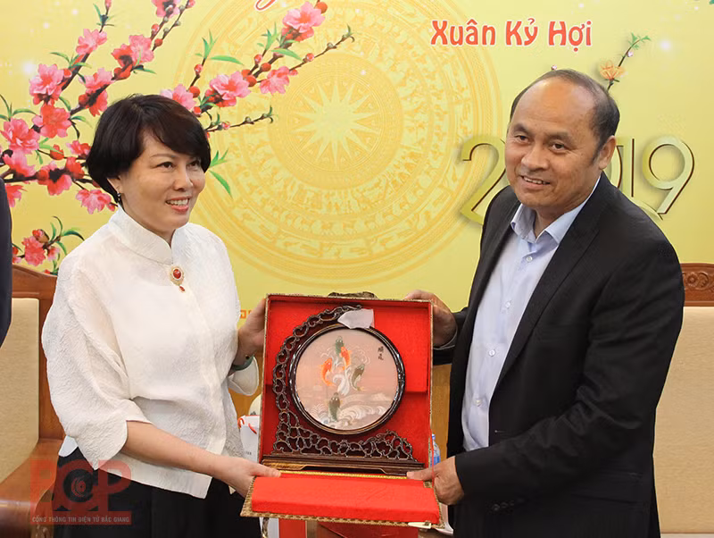 Đại diện Tập đoàn máy tính Lenovo (bên trái) tặng quà lưu niệm cho Chủ tịch UBND tỉnh Nguyễn Văn Linh (Ảnh: BGP/Hải Huyền)