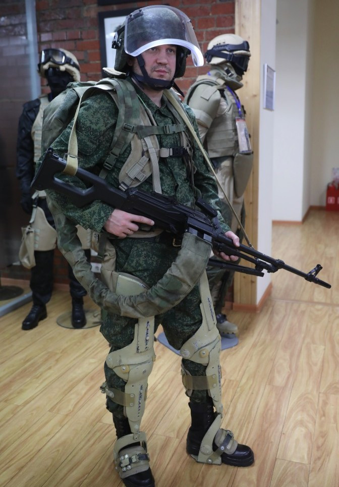 Xạ thủ súng máy với ba lô tiếp đạn và bộ khung xương chịu lực EO-1. Ảnh warsonline Xạ thủ súng máy với ba lô tiếp đạn và bộ khung xương chịu lực EO-1. Ảnh warsonline