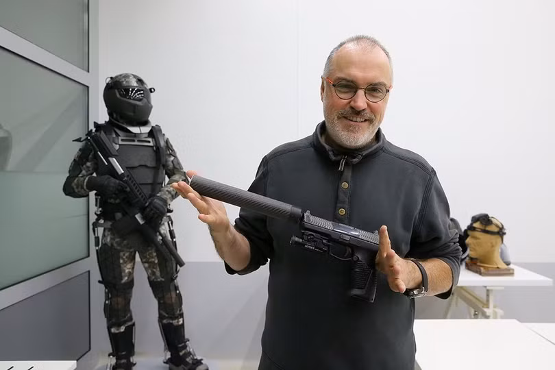 Nhà mỹ thuật công nghiệp Vladimir Pirozhkov với súng ngắn Udar gắn nòng giảm thanh. Ảnh: RIA Novosti. Nhà mỹ thuật công nghiệp Vladimir Pirozhkov với súng ngắn Udar gắn nòng giảm thanh. Ảnh: RIA Novosti.