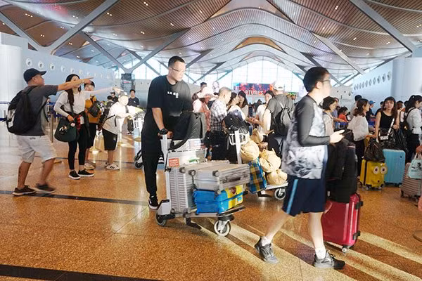 Du khách Trung Quốc làm thủ tục hàng không trước khi về nước tại Sân bay Quốc tế Cam Ranh. Ảnh: Minh Duy