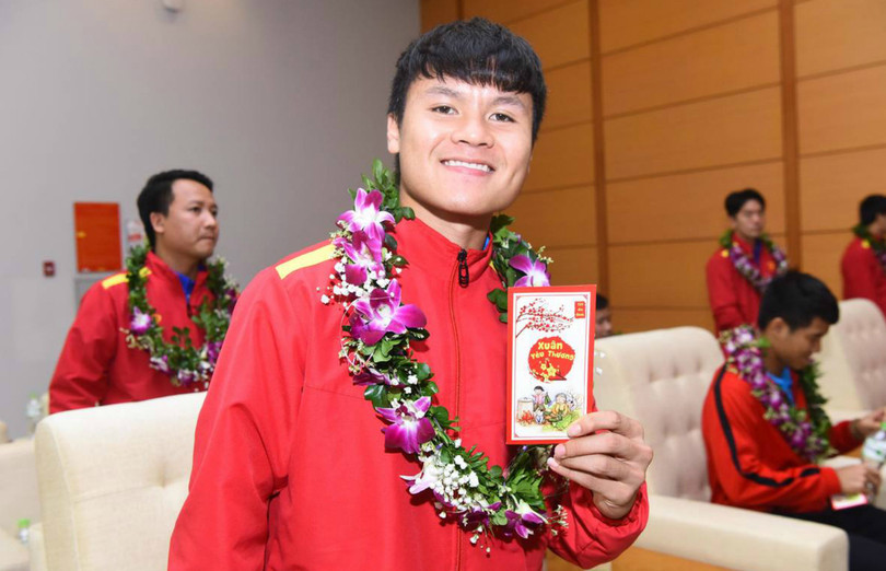 Các thành viên đội tuyển nhận tiền lì xì trong buổi tiếp đón tại sân bay (Ảnh: VnExpress) Quang Hải nhận tiền lì xì