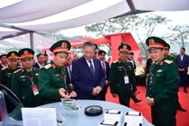 Tổng bí thư Tô Lâm nghe giới thiệu về công nghệ chip bán dẫn tại khu vực triển lãm của Viettel trong lễ khởi công nhà máy chip đầu tiên của Việt Nam.