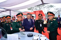 Tổng bí thư Tô Lâm nghe giới thiệu về công nghệ chip bán dẫn tại khu vực triển lãm của Viettel trong lễ khởi công nhà máy chip đầu tiên của Việt Nam.