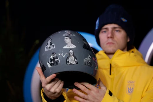 Vận động viên Vladyslav Heraskevych của Ukraine giơ cao chiếc mũ bảo hiểm đặc biệt tại một cuộc họp báo. Ảnh: Reuters.