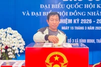 Cán bộ tổ bầu cử ở Hà Nội giúp cụ bà di chuyển sau khi bỏ phiếu. 