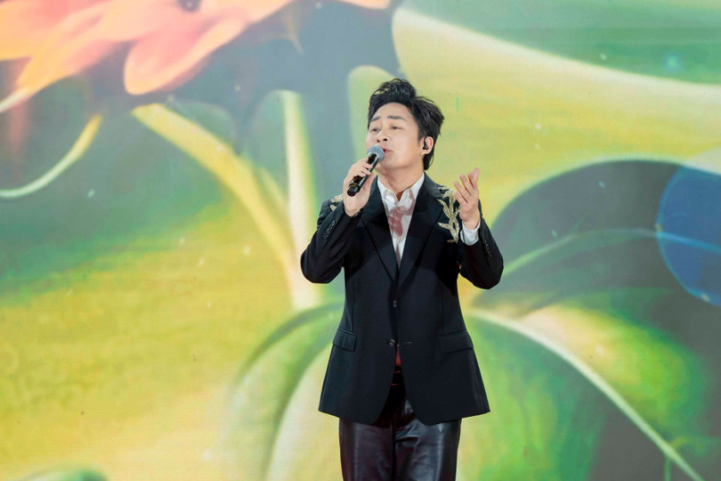 Ca sĩ Tùng Dương biểu diễn trong chương trình nghệ thuật mở màn, với nền hình ảnh tái hiện ký ức đại dịch phía sau sân khấu.