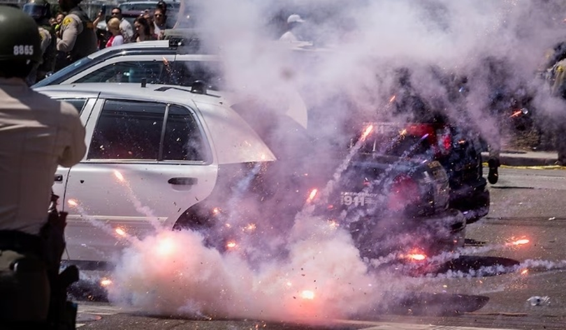 Nhân viên thực thi pháp luật phóng đạn gây choáng vào người biểu tình. Ảnh: QQnews.