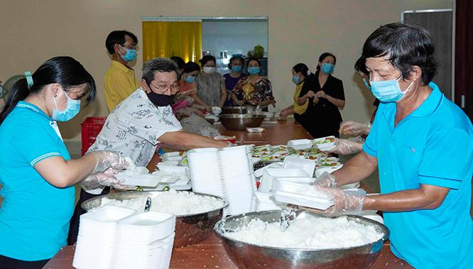 Nhiều người dân đã thức suốt đêm nấu cơm, chuối, bắp, khoai lang… mang đến khu cách ly tập trung để tiếp tế lực lượng tuyến đầu, tiếp thêm thực phẩm, nước uống, mừng con em mình trở về quê hương. Ảnh: Mạnh Hùng.