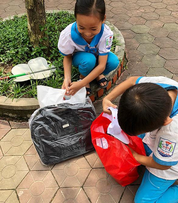 Những đứa trẻ vùng lũ lụt miền Trung thích thú với món quà mới để sớm đến trường sau khi lũ rút năm 2020. Ảnh NVCC.