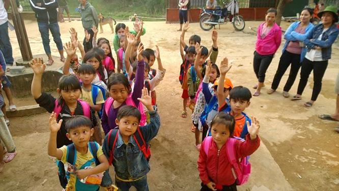 Trẻ em ở huyện miền núi Phước Sơn (tỉnh Quảng Nam) háo hức nhận quà đi học từ công ty của anh Phạm Văn Dũng trao tặng, sau trận lũ kinh hoàng năm 2020. Ảnh NVCC.