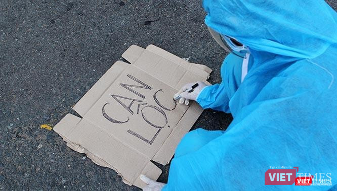 Viết vội tên huyện lên tấm bìa các tông ngay tại sân ga để tập hợp bà con, bởi thời gian gấp quá không kịp in ấn. Ảnh: GVT.