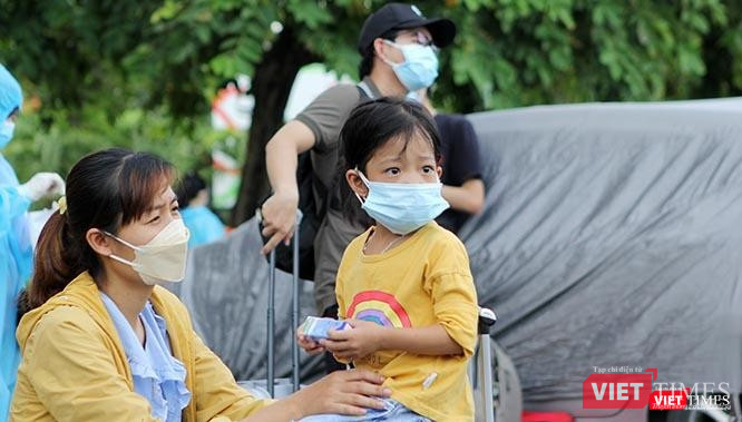 Ngơ ngác tại sân ga Sài Gòn khi thấy nườm nượp người giấu kín mình trong bộ đồ phòng hộ màu lam, cháu bé này khó có thể hình dung ra mình là hành khách nhí trên chuyến tàu đặc biệt trong đời di chuyển về quê giữa khi dịch Covid-19 đang bùng phát. Ảnh: GVT.