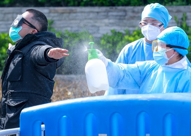 Nhân viên y tế ở Vũ Hán khử trùng bệnh nhân trước khi ra viện.(Ảnh Đông Phương).