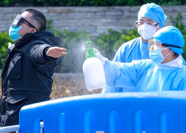 Nhân viên y tế ở Vũ Hán khử trùng bệnh nhân trước khi ra viện.(Ảnh Đông Phương).