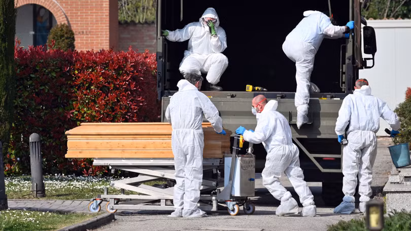 Số người chết vì COVID-19 ở Italy đang tăng rất nhanh. Trong ảnh: các nhân viên phòng dịch chuyển thi hài người chết đi xử lý (Ảnh: Đa Chiều).