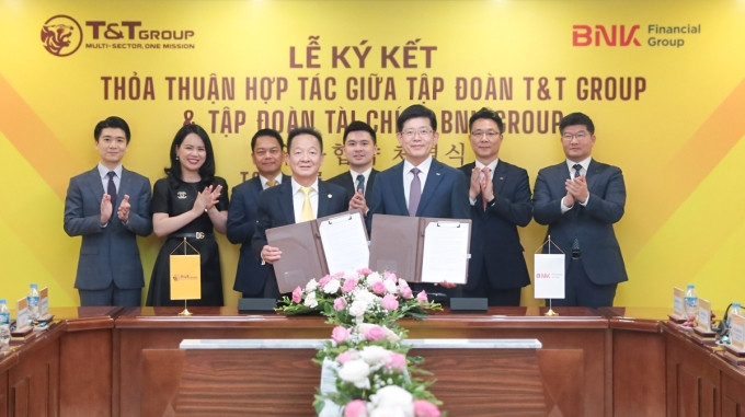Ông Đỗ Quang Hiển - Chủ tịch Ủy ban Chiến lược T&amp;T Group (trái) và ông Bin Dae-in - Chủ tịch HĐQT kiêm Tổng giám đốc Tập đoàn Tài chính BNK (phải) trao thỏa thuận hợp tác. Ảnh: T&amp;T Group