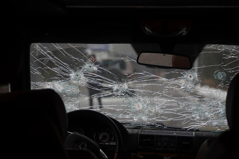 Một xe cảnh sát bị những người bạo loạn bắn trực diện với những vết đạn trên kính phía trước (Ảnh: AP).