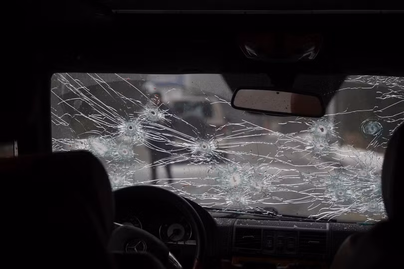 Một xe cảnh sát bị những người bạo loạn bắn trực diện với những vết đạn trên kính phía trước (Ảnh: AP).