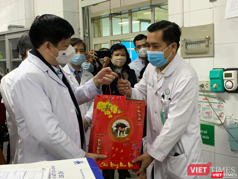 Bộ trưởng Bộ Y tế Nguyễn Thanh Long (trái) tặng quà các thầy thuốc trong kíp trực ngày 30 tết ở BV Việt Đức