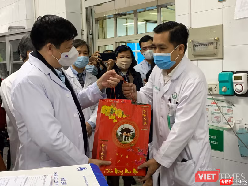 Bộ trưởng Bộ Y tế Nguyễn Thanh Long (trái) tặng quà các thầy thuốc trong kíp trực ngày 30 tết ở BV Việt Đức